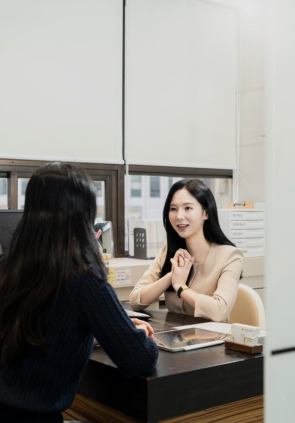 상담실에서 직원이 환자와 마주 앉아 이야기(세로 사진)