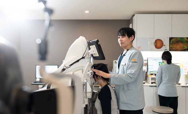 검사실에서 직원이 환자의 검사 자세를 잡아 주는 모습